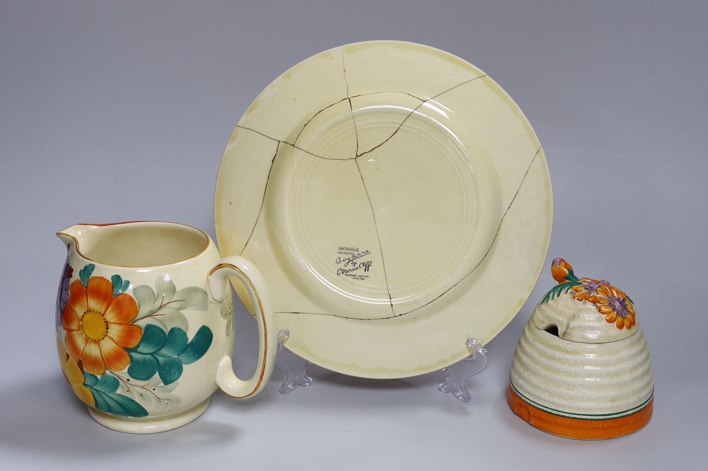 An early Clarice Cliff Fantasque plate, a Clarice Cliff honey pot and a Gray's jug, a.f.